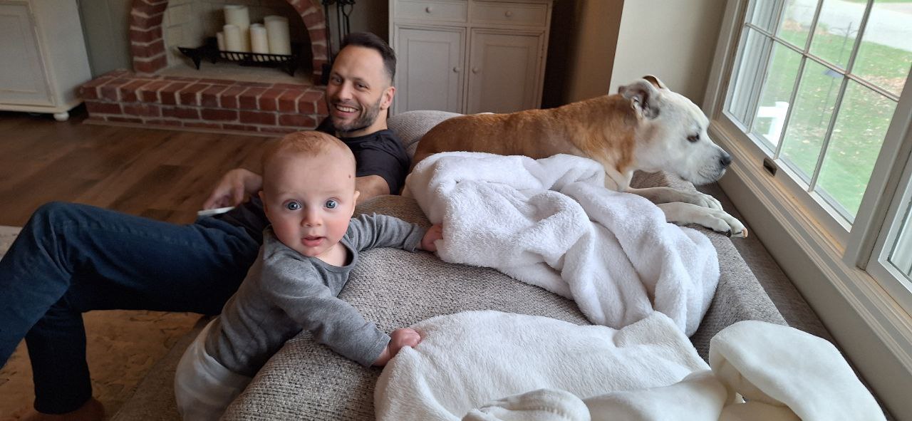 Dad baby and pitbull on couch